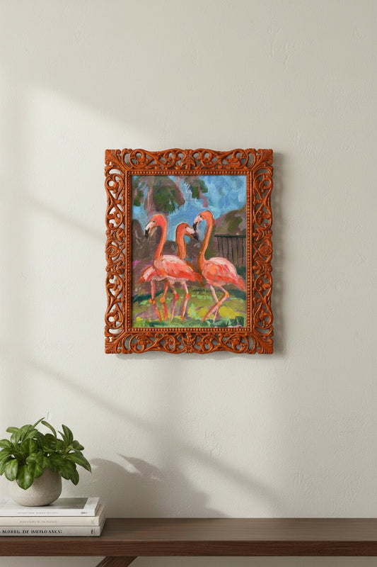 Three pink flamingos in a natural setting with greenery and water.
