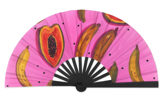 Hand fan with tropical fruit design on a pink background