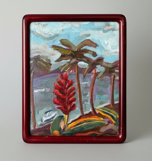 Framed painting of tropical landscape with palm trees and red flower.