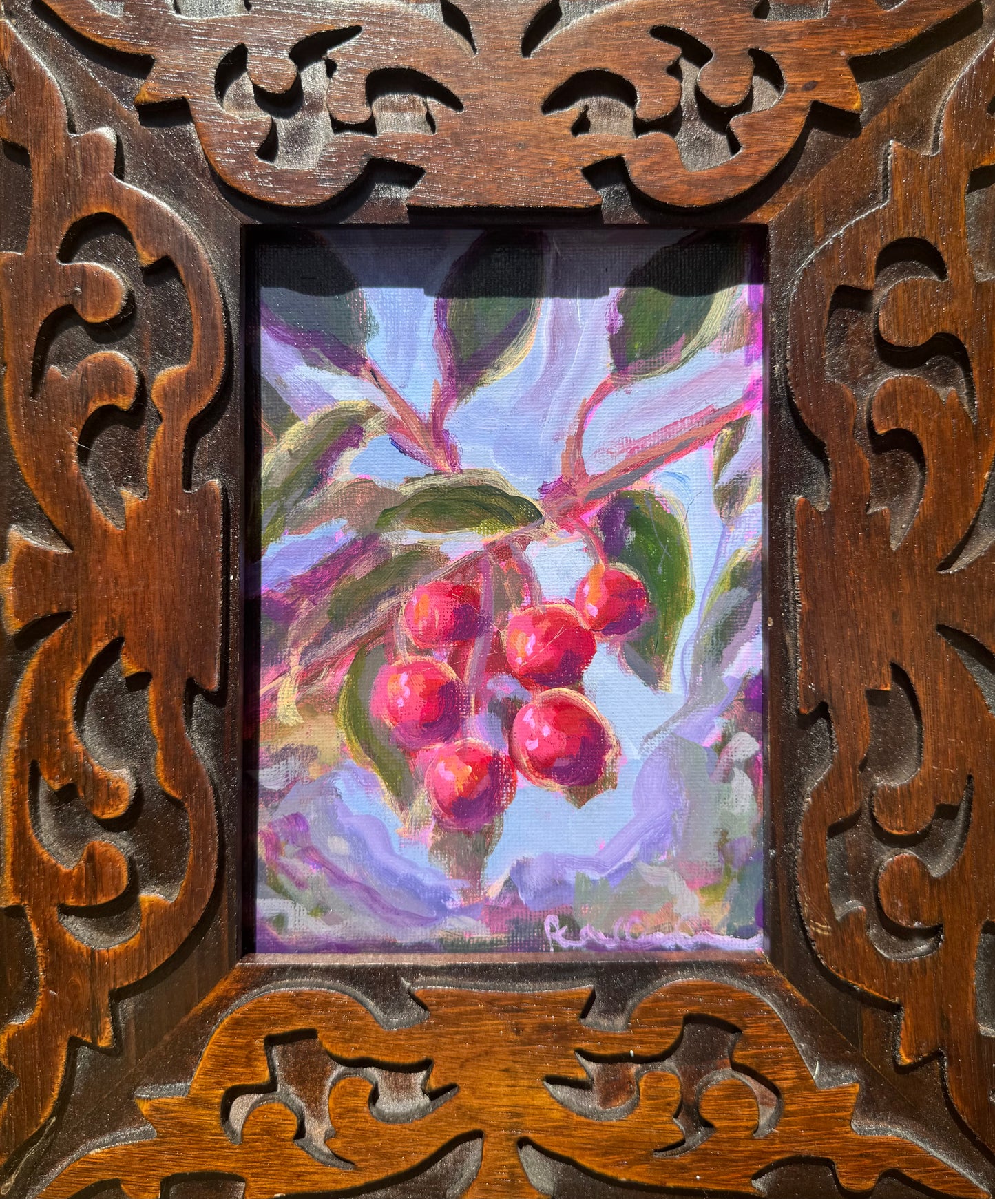 Decorative wooden frame with a painting of berries and leaves inside