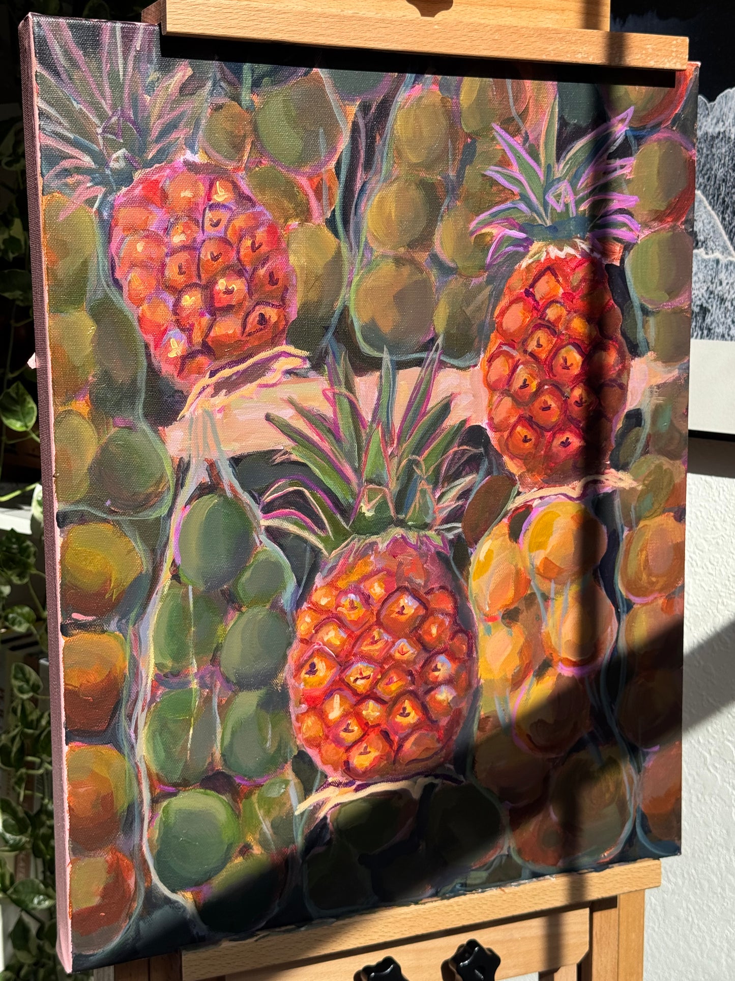 Colorful painting of pineapples and limes on a wooden surface
