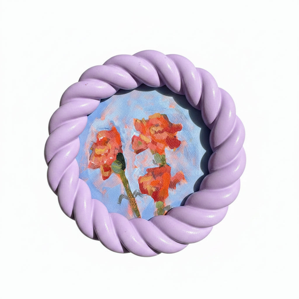 Round painting of orange flowers in a purple frame on a white background