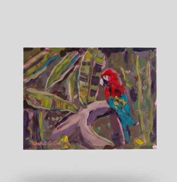 Hand holding a colorful painting of a parrot and leaves