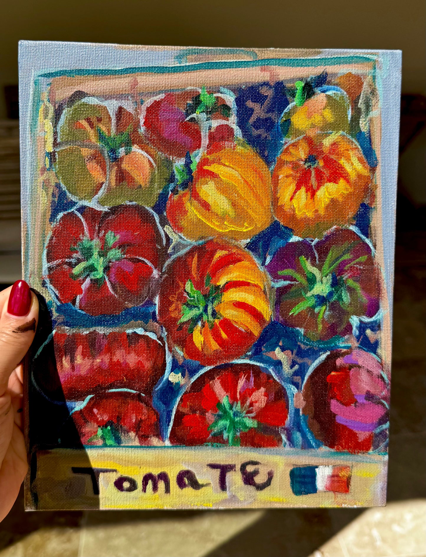 Painting of tomatoes with a hand holding it