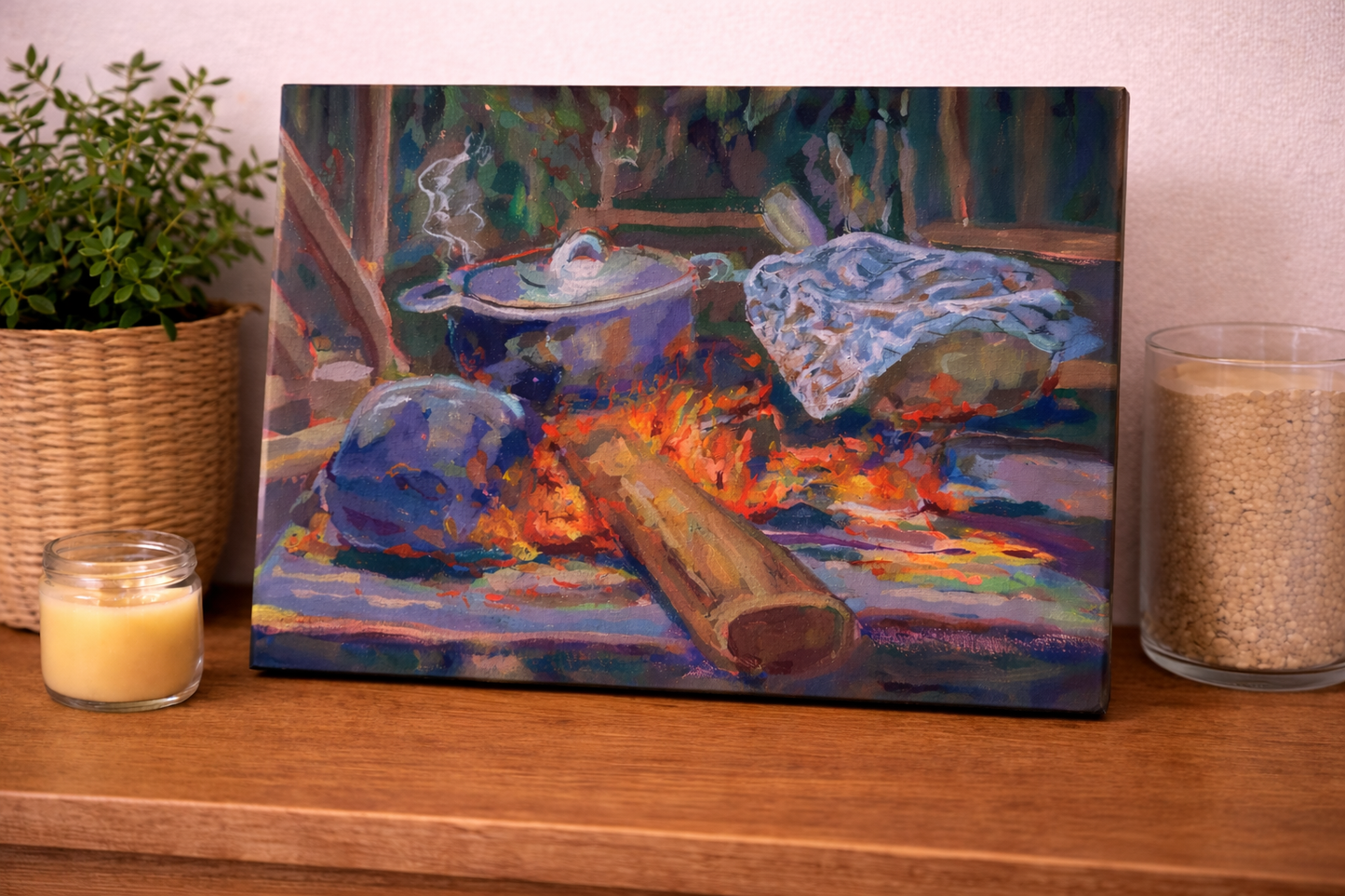 Canvas print of a painting on a wooden surface with candles and a plant.