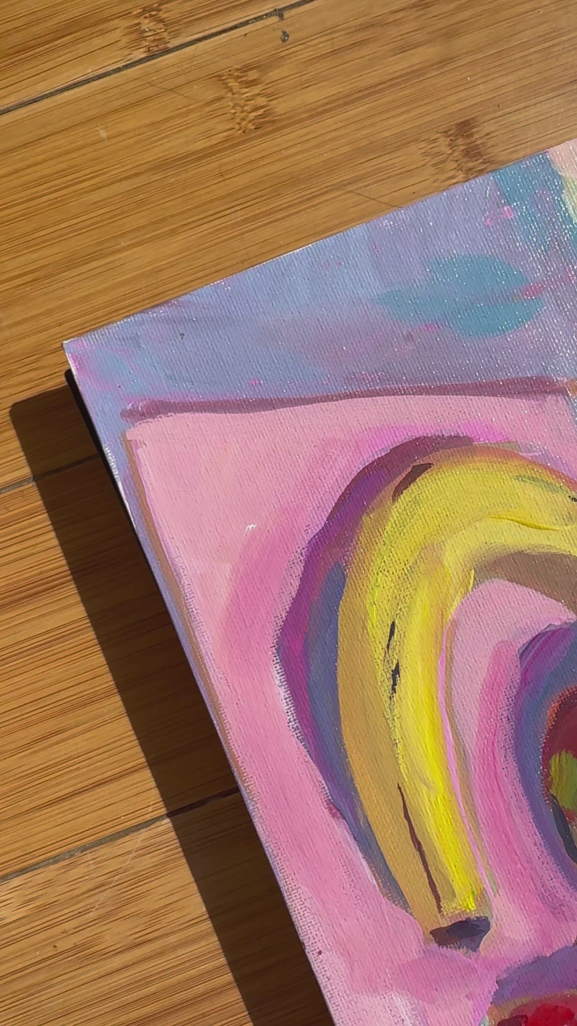 Video of fruit painting colorful - banana, strawberry and pear on pink and blue. Video shows wood background. 